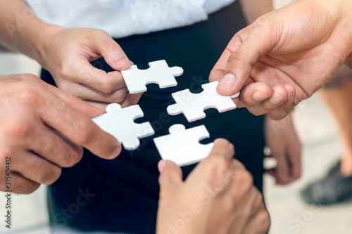 Close-up ,Hand of business people holding jigsaw puzzle.