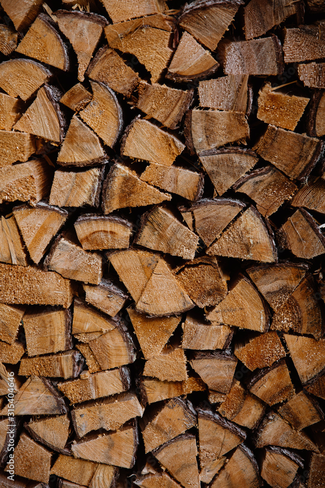 Closeup of neatly stacked dry brown firewood for stock at Dolomites mountains at Italy Closeup of neatly stacked dry brown firewood for stock at Dolomites mountains at Italy