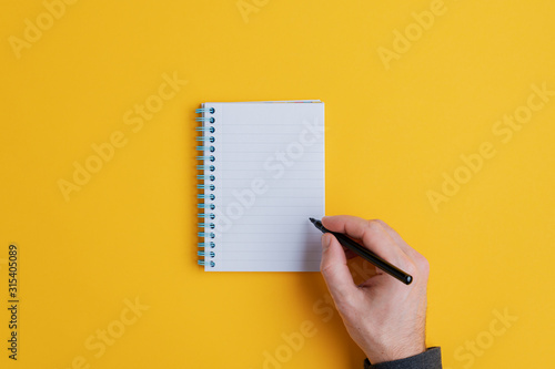 Male hand about to write in notebook photo