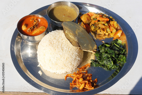 Dal Bhat, Traditional Nepali Food with Curry, Lentils, Rice, Spinach, and pickles photo