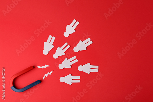 Magnet and paper people on red background, flat lay photo