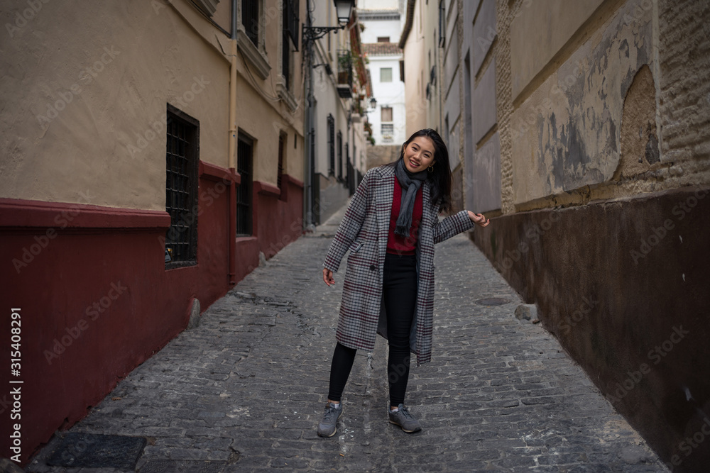 Joyful Asian resting female hiking on old rocked narrow street Joyful Asian resting female hiking on old rocked narrow street