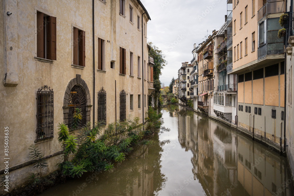 From above of drowned narrow street with green plants between old beautiful buildings at Padova at Italy From above of drowned narrow street with green plants between old beautiful buildings at Padova at Italy