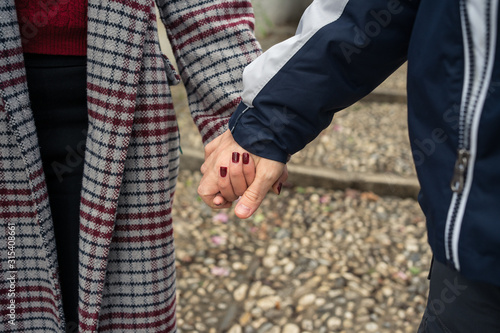 From above of anonymous crop male and female lovers in casual clothing holding hands while walking at Albaicin in Granada  photo