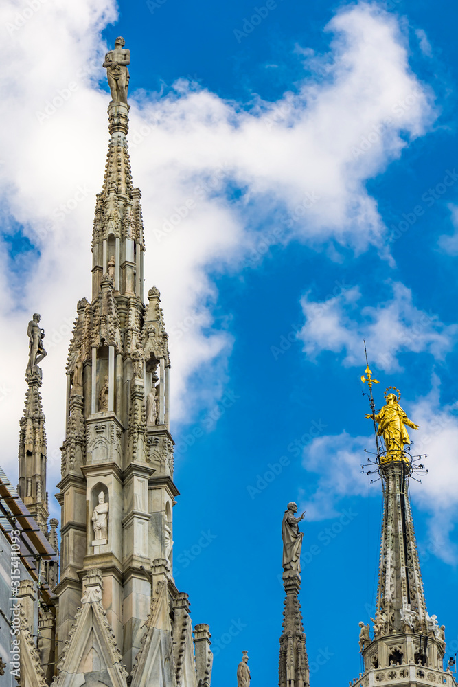 White marble spires on the roof of famous Cathedral Duomo di Milano in Milan, Italy