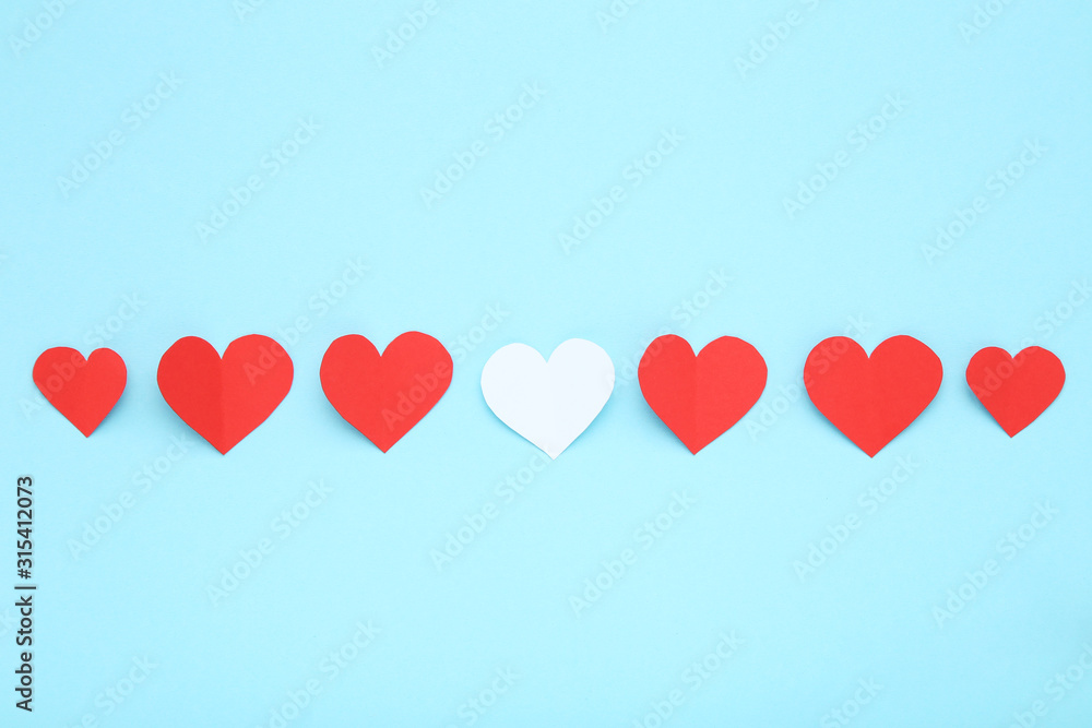 Red and white paper hearts on blue background