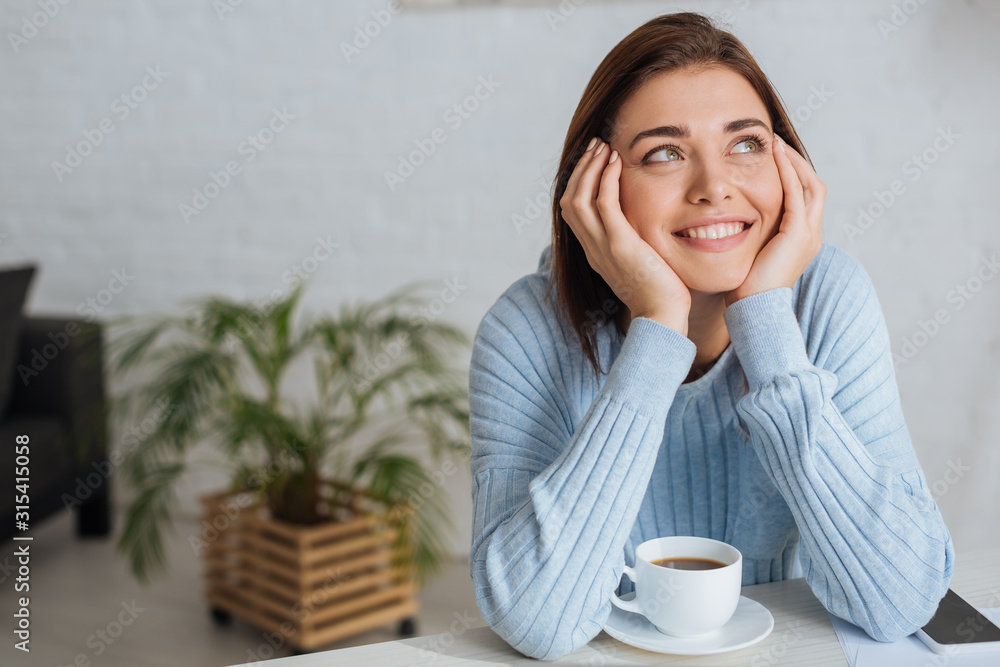 dreamy young woman smiling near cup with coffee dreamy young woman smiling near cup with coffee