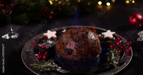 Christmas Pudding with flames / Plum / Figgy - British Traditional Christmas dinner festive desert. Tracking Shot shot photo