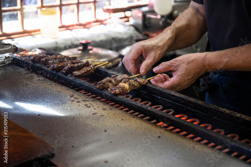 Japan, Takayama, Hands of chef grilling yakitori