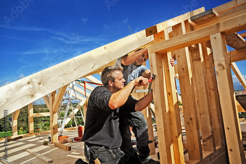 Carpenters Setting up a Half-timbered Building and the Roof Structure photo