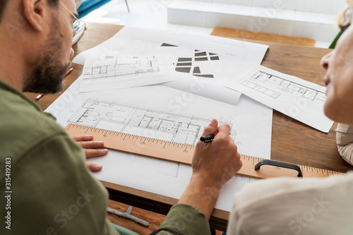 Crop view of two architects working together at desk in office photo