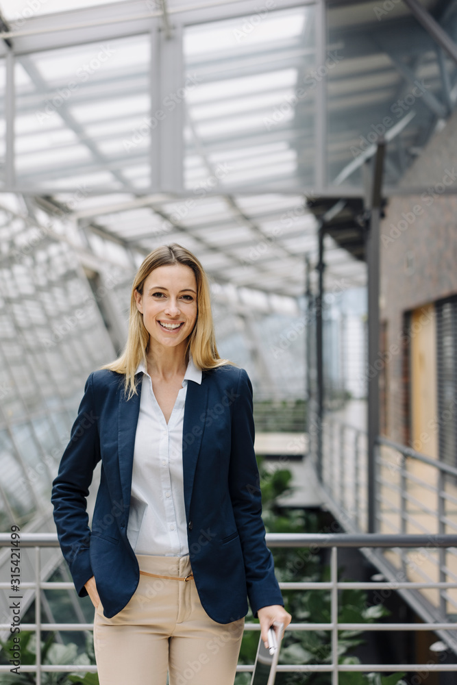 Portrait of a smiling young businesswoman in a modern office building Portrait of a smiling young businesswoman in a modern office building
