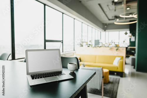 Wallpaper Mural Business, Laptop and cup in coworking office Torontodigital.ca