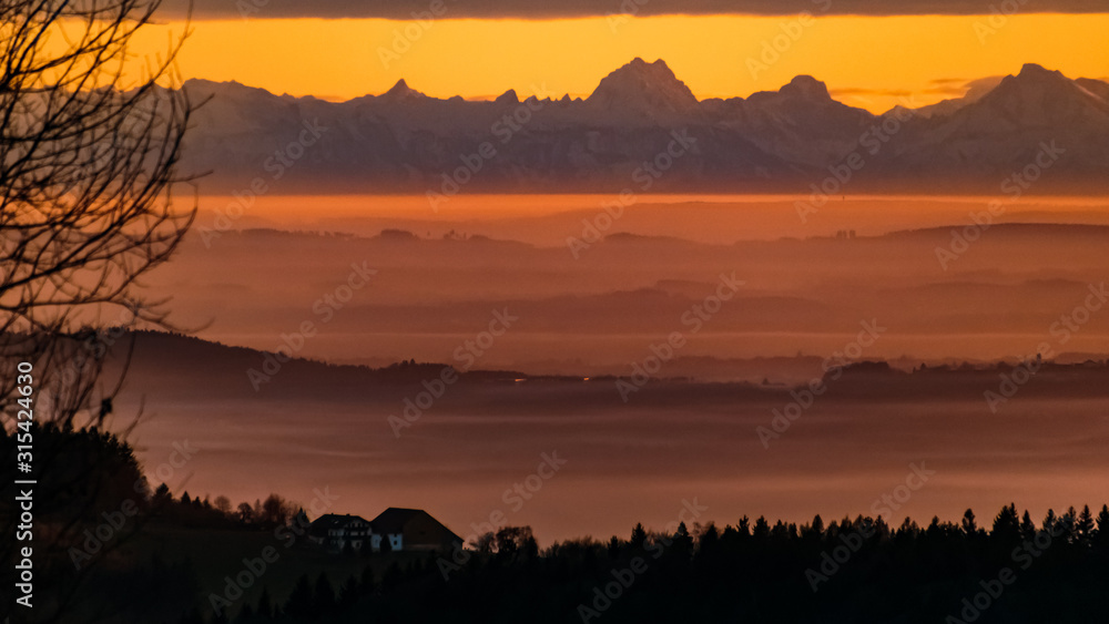 Beautiful sunset with the distant alps in the background near Daxstein, Bavarian forest, Bavaria, Germany