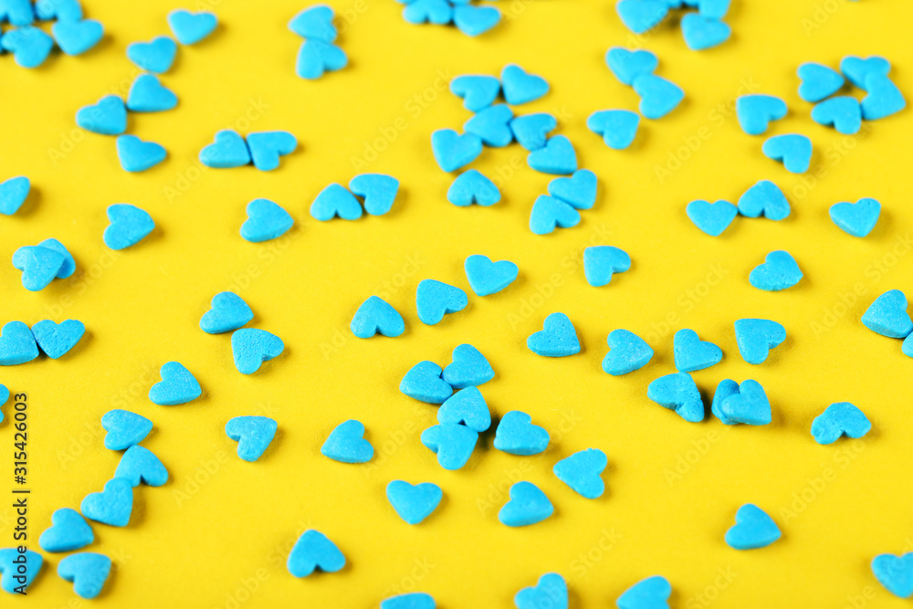 Heart shaped sprinkles on yellow background