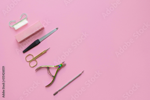 Manicure tools on pink paper background