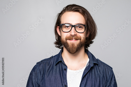 Young man with glasses smiling isolated on gray background