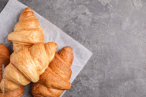 Tasty fresh croissants on grey table  flat lay. Space for text