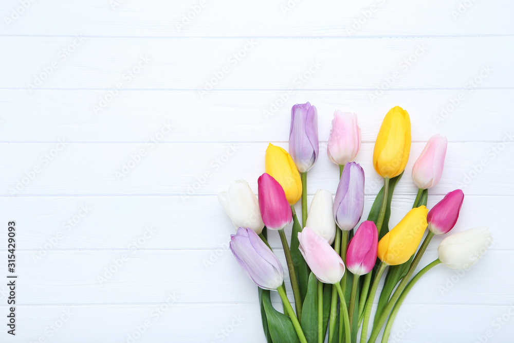 Fototapeta premium Bouquet of tulip flowers on white wooden table