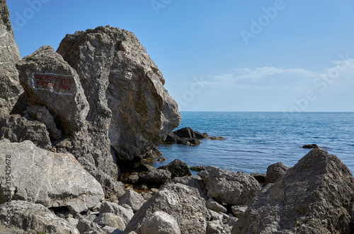 Obraz na płótnie The rocky coast of the Black Sea. Cape Alchak in Sudak, Crimea. The inscription on the rock
