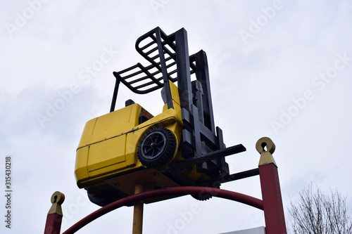 Model of Yellow Fork Lift Truck on Metal Stand  photo