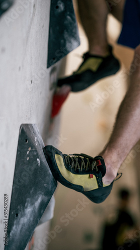 Mann beim Bouldern an Kletterwand photo