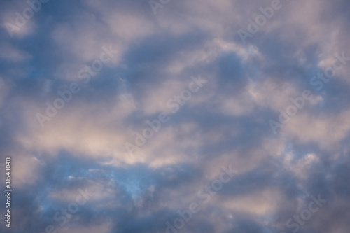 Blue winter sky and cumulus heavy clouds. Windy weather. High quality photo.