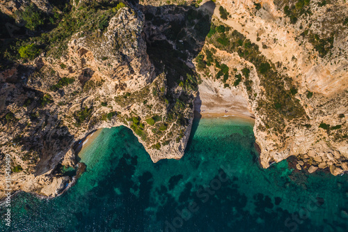 Aerial drone view on secret cozy beach sheltered between two rocky headlands Cala Moraig, Valencia community, Spain