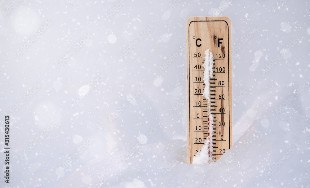 Obraz premium Wooden thermometer in the winter. 