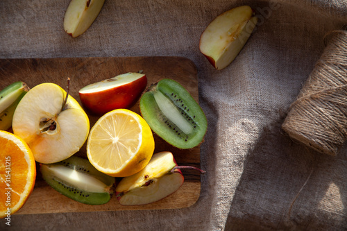 sliced fruits on a wooden board, on a forest towel