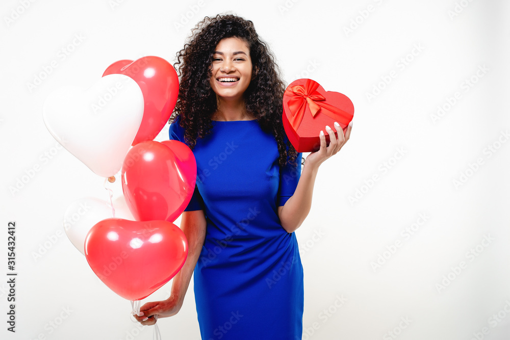 beautiful woman with red heart shaped gift box and colorful balloons isolated over white beautiful woman with red heart shaped gift box and colorful balloons isolated over white