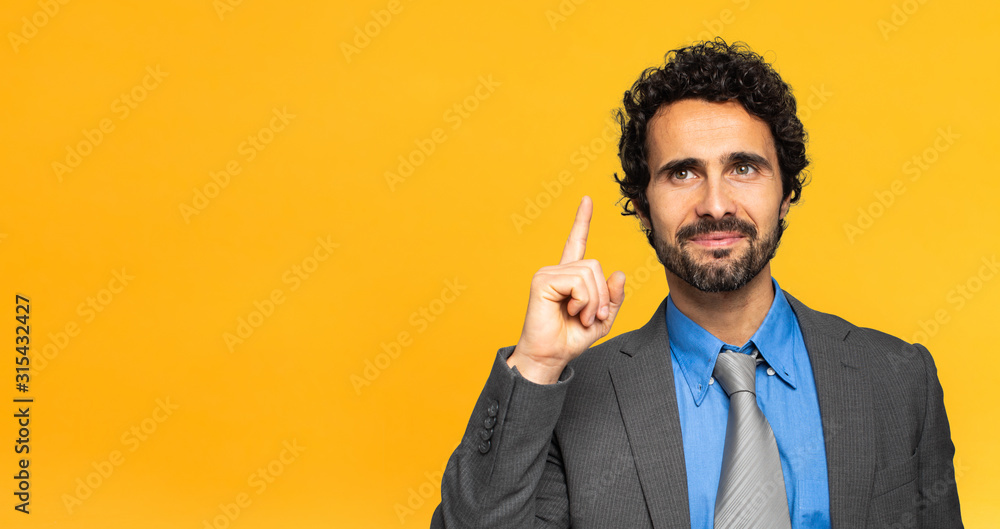 Young businessman having the solution on yellow background - obrazy, fototapety, plakaty 