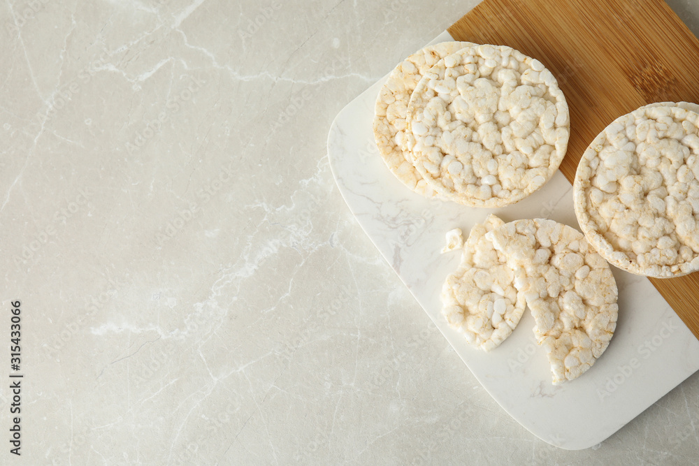 Puffed rice cakes on grey marble table, top view. Space for text