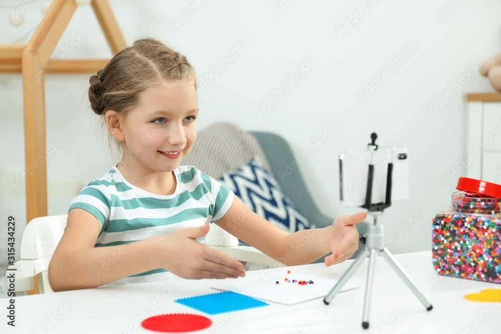Cute little blogger with handcrafting recording video at home Cute little blogger with handcrafting recording video at home