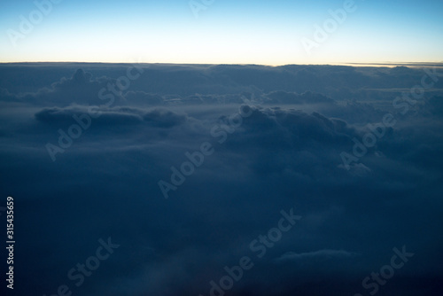 blue sky background with white clouds. Puffy clouds horizon. View from the airplane window. DARK BLUE CLOUDS BACKGROUND, NATURE BLUE SKIES