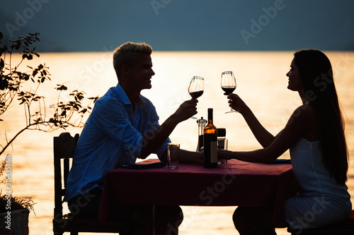 Happy couple on summer evening having romantic dinner outdoor