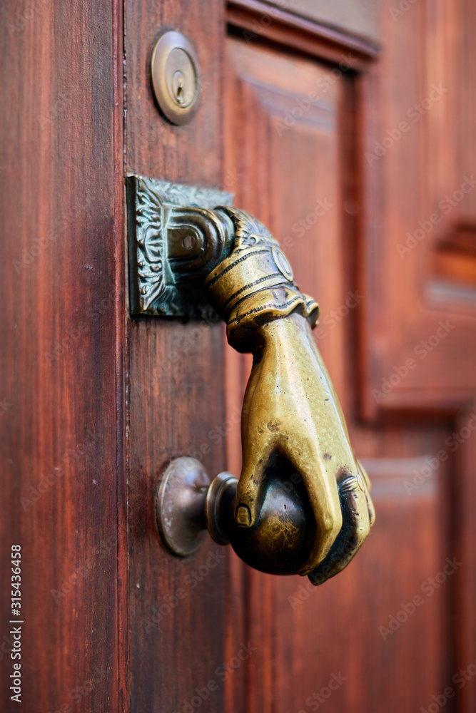 Aldaba con forma de mano en puerta de madera Stock Photo | Adobe Stock