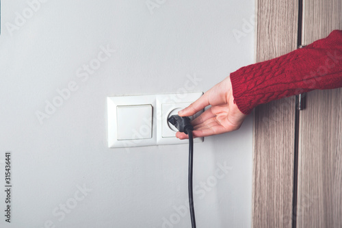 A woman hand pulls a black cord