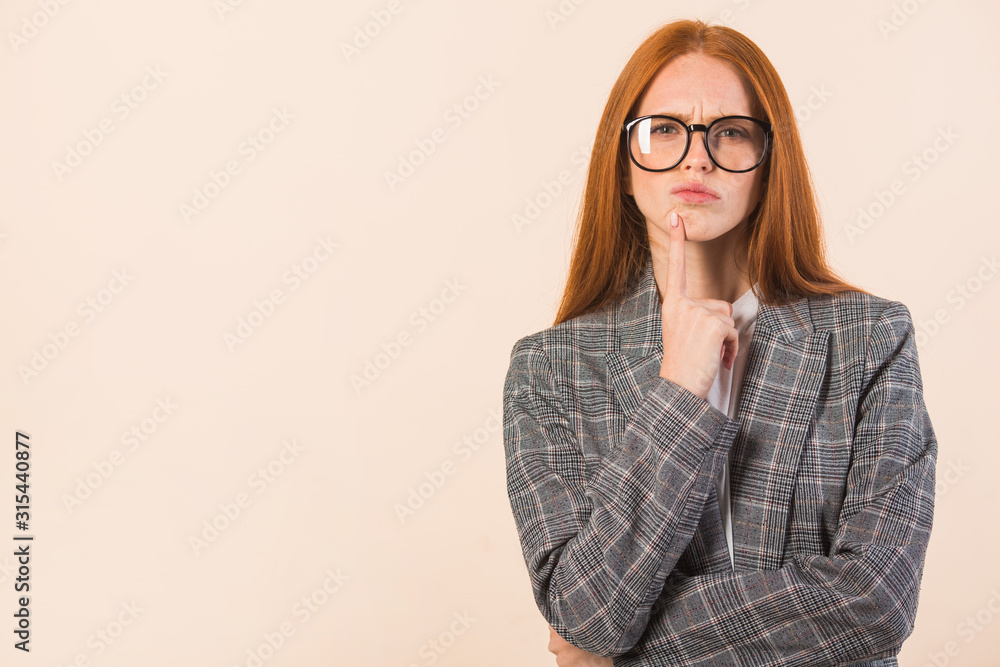 beautiful young woman with red hair in a jacket on a beige background beautiful young woman with red hair in a jacket on a beige background