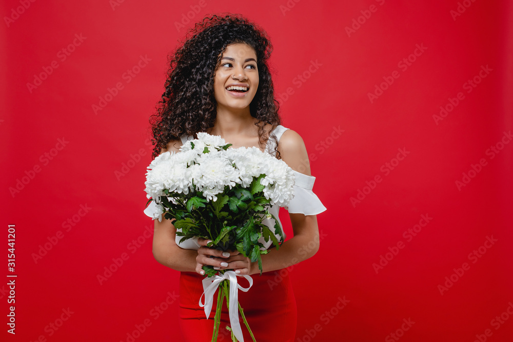 beautiful black woman smiling with bouquet of white flowers isolated over red beautiful black woman smiling with bouquet of white flowers isolated over red
