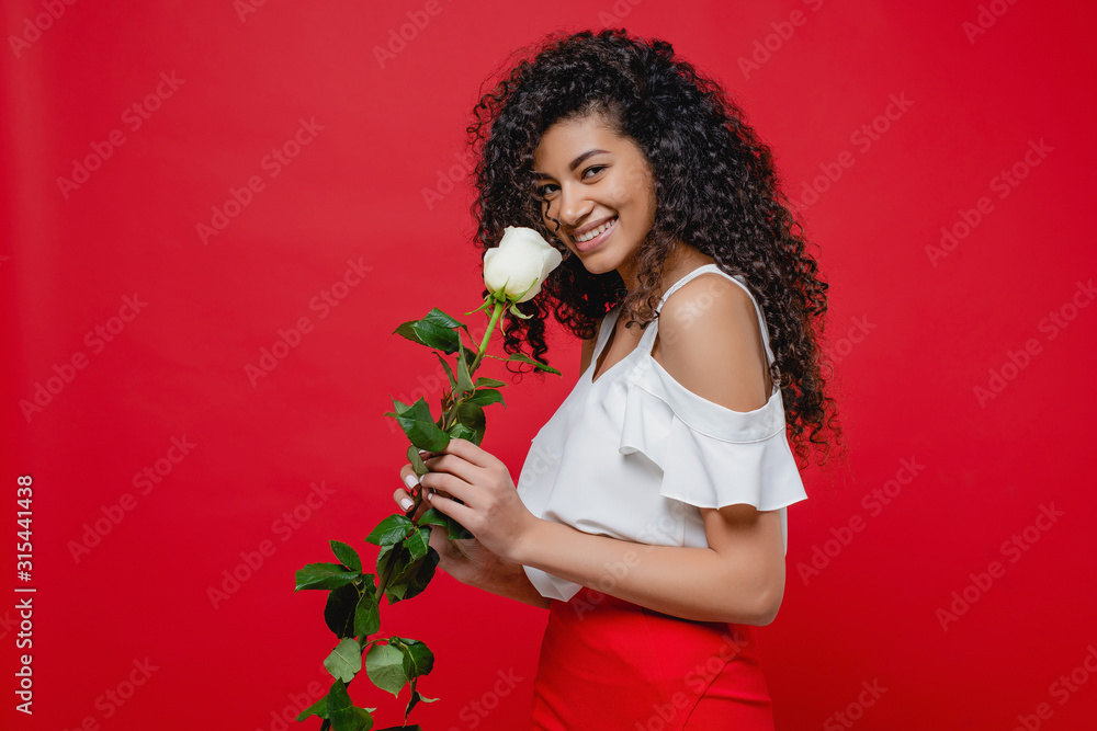 beautiful black woman smiling with white rose isolated over red beautiful black woman smiling with white rose isolated over red