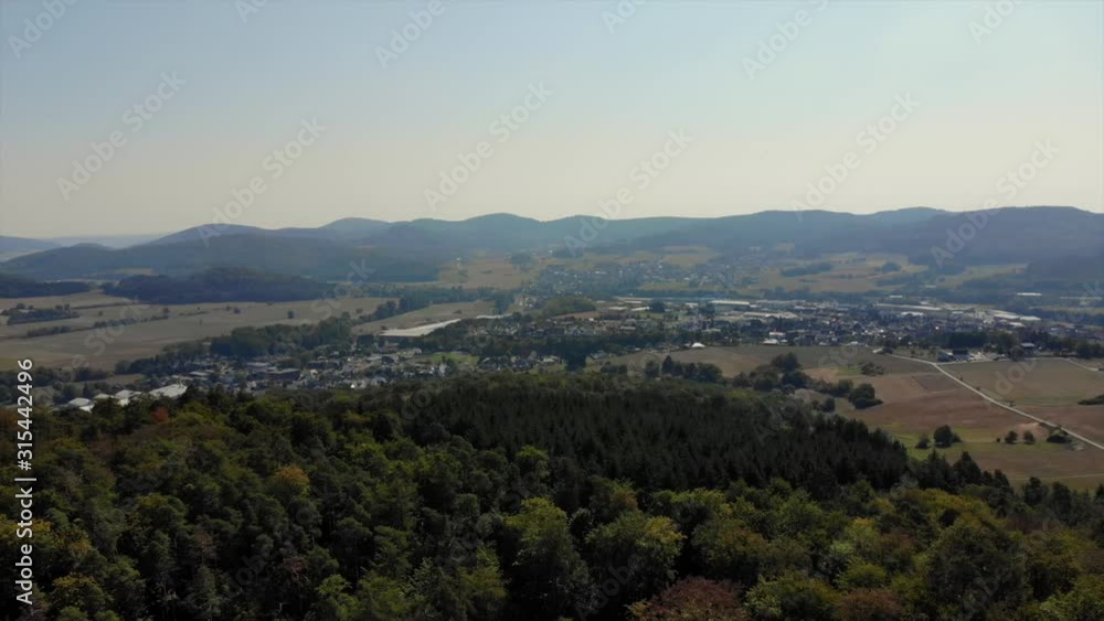 Drone flying towads small rural town at base of mountains Drone flying towads small rural town at base of mountains