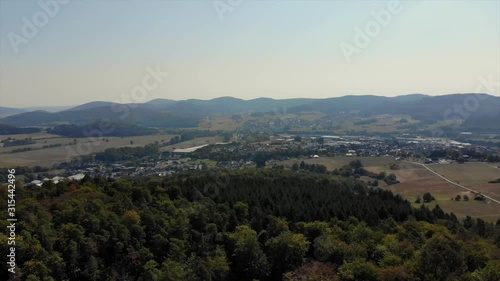 Drone flying towads small rural town at base of mountains photo