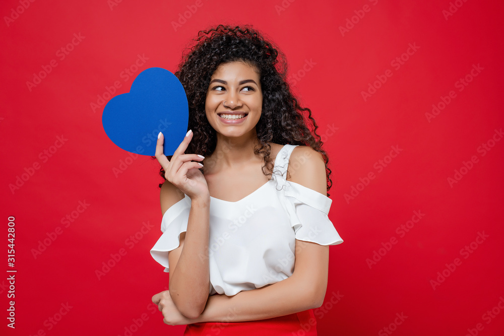 beautiful black woman with blue heart shaped valentine card isolated over red beautiful black woman with blue heart shaped valentine card isolated over red