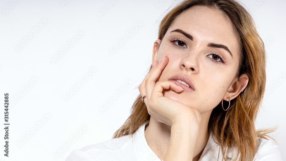 close-up portrait of a young girl with a pensive look on a white background, copy space close-up portrait of a young girl with a pensive look on a white background, copy space