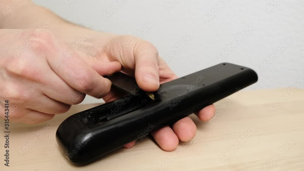 Loading batteries into a remote control. Close up. Loading batteries into a remote control. Close up.
