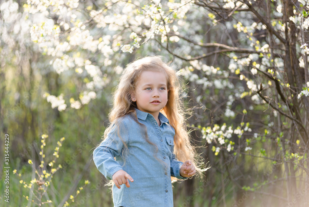 Little blonde girl having fun in the spring park. Little blonde girl having fun in the spring park.