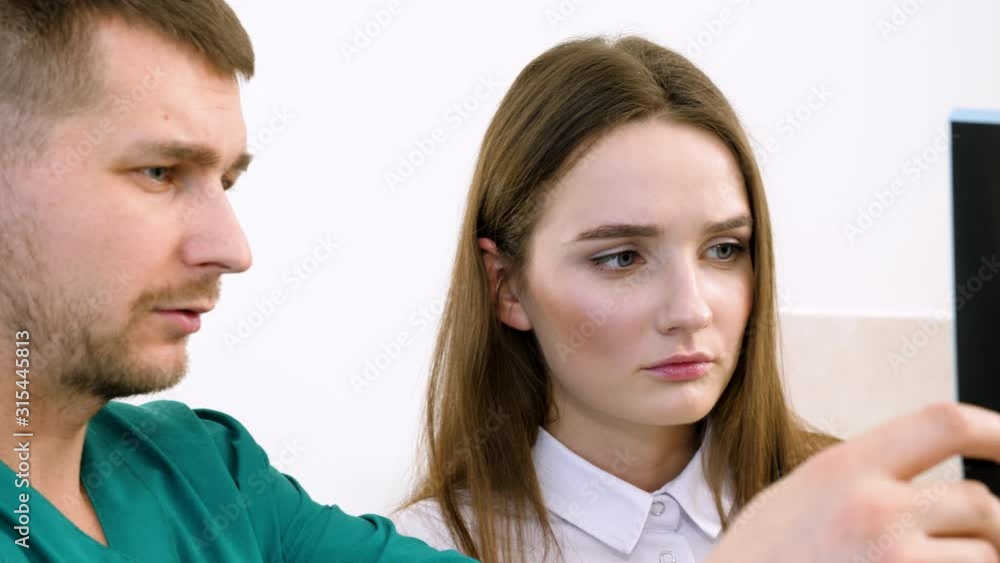 Medical team in meeting, looking at patient x-rays of lungs in modern clinic. 4K
