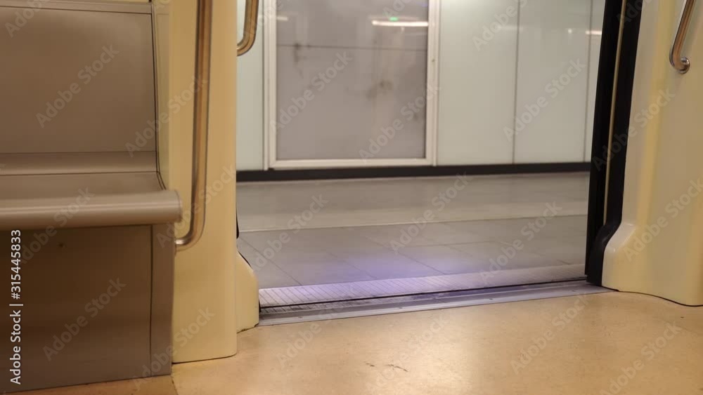 Interior of european subway train, underground train waiting at the station platform with opened doors. Timetable of public underground transport, empty carriage and opened vehicle doors