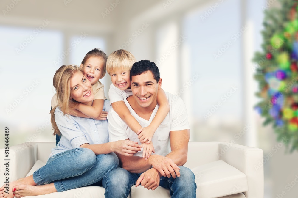 Beautiful smiling family sitting at sofa at home Beautiful smiling family sitting at sofa at home
